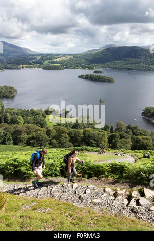 Wanderer auf den unteren Hängen des Catbells mit Derwent Wasser unten, Lake District, Cumbria UK Stockfoto