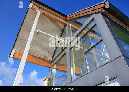 Moderner Bau mit großen Glasfenstern vor blauem Himmel Stockfoto
