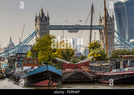 Hausboote und Lastkähne vertäuten in der Nähe der Tower Bridge in Bermondsey mit dem Walkie Talkie Building, in der Ferne, London, Großbritannien Stockfoto