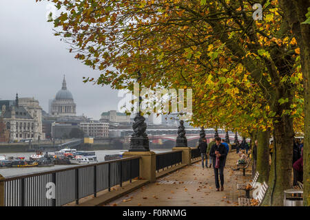 Menschen zu Fuß entlang der Themse an der South Bank, während der Herbst mit St. Paul's Cathedral in der Ferne, South Bank, London, UK Stockfoto