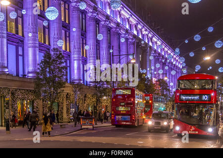 Londoner Busse vor Selfridges auf der Oxford Street sind zu Weihnachten mit Weihnachtseinkäufern beschäftigt und die Oxford Street Lichter sind ausgestellt, London, UK Stockfoto