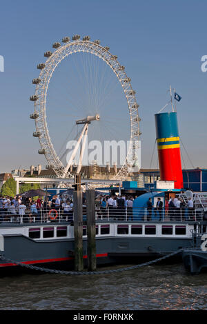 Menschen an Bord Tattershall Castle, eine schwimmende Bar auf der Themse mit dem London Eye im Hintergrund Stockfoto