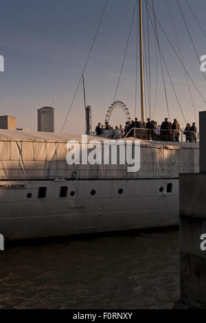 Gäste an Bord der HQS Wellington vertäut einem privaten Veranstaltungsort auf der Themse in London Stockfoto