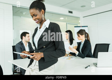 Jung, schwarz, afrikanische Geschäftsfrau mit einem Tablet auf einem Büro-treffen Stockfoto