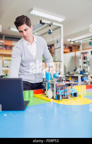 Männliche Elektroingenieur Programmierung eines Roboters während Robotik-Klasse Stockfoto