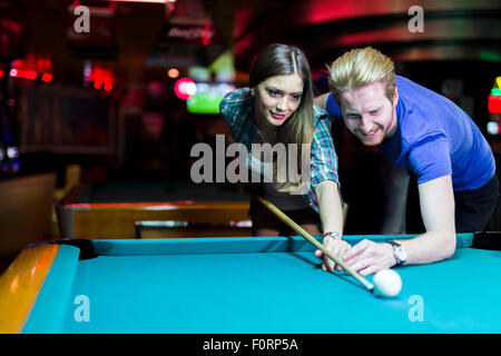 Schönen jungen Mann und Frau flirten beim Billard spielen Stockfoto