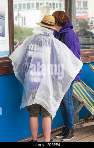 Bournemouth, Dorset, Großbritannien. 20. August 2015. Festivalmacher des Bournemouth Air Festivals halten sich bei schlechtem Wetter unter Schutz am Pier und tragen einen Plastikponcho zum Schutz vor Regen. Quelle: Carolyn Jenkins/Alamy Live News Stockfoto