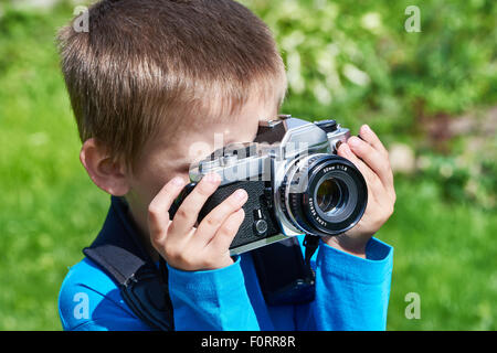 Kleiner Junge mit Retro-SLR Kamera Außenaufnahmen Stockfoto