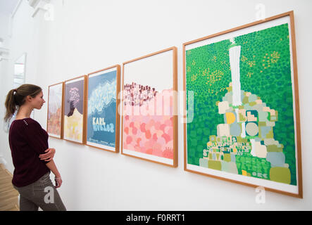 Eine Frau schaut auf Plakaten während eines Presse-Preview der Ausstellung "Poster Rock Gig Poster und der Flatstock-Konvention" auf der Museum Fuer Kunst Und Gewerbe in Hamburg, Deutschland, 20. August 2015. Die Ausstellung läuft bis 01. November zahlreiche Siebdruck Drucke zeigt und Poster gig. Foto: DANIEL BOCKWOLDT/dpa Stockfoto