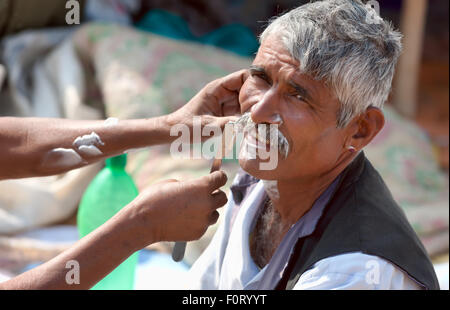 PUSHKAR, Indien - NOVEMBER 20: Ein unbekannter Mann aus Straße Friseur an der Pushkar fair am 20. November 2012 in Pushka rasiert Stockfoto