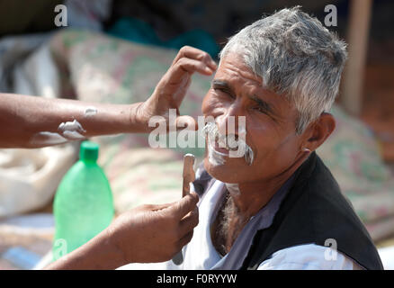 PUSHKAR, Indien - NOVEMBER 20: Ein unbekannter Mann aus Straße Friseur an der Pushkar fair am 20. November 2012 in Pushka rasiert Stockfoto