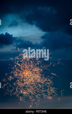 Goldenes Feuerwerk in frühen Abendhimmel am Unabhängigkeitstag. Stockfoto