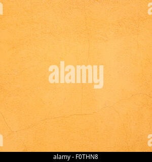 Orange bemalten Wand mit Stuck Render Textur und Risse, ideal für einen Vintage-Hintergrund Stockfoto