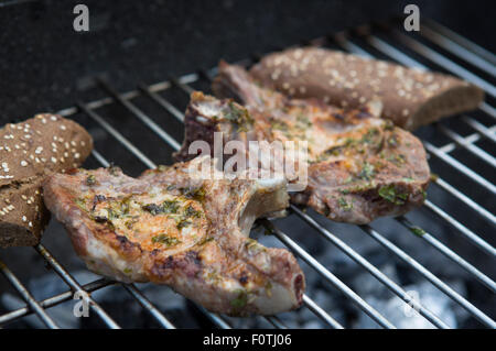 Zwei Schweineschnitzel auf einem Holzkohle Grill gefeuert Stockfoto