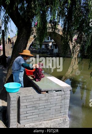 Wäsche an den Ufern des Fenjing die antike Stadt Wasserstraßen. Stockfoto