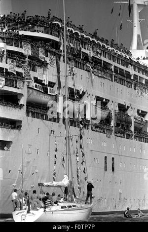 AJAXNETPHOTO. 11TH. JULI 1982. SOUTHAMPTON, ENGLAND. - WAL KEHRT ZURÜCK - S.S.CANBERRA, VON DER MOD ALS TRUPPENSCHIFF WÄHREND DES FALKLAND-KONFLIKTS ANGEFORDERT, KEHRT MIT TRUPPEN, BEGLEITET VON EINER RIESIGEN FLOTTE VON BRUNNENFISCHERN, NACH HAUSE ZURÜCK. FOTO: JONATHAN EASTLAND/AJAX. REF:820711 3 23A.HD LIN CAN. Stockfoto