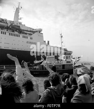 AJAXNETPHOTO. 12. MAI 1982. SOUTHAMPTON, ENGLAND. -TRUPPENTRANSPORTER FÄHRT. DIE CUNARD LINER QE2 FÄHRT AM KAI IN SOUTHAMPTON, BELADEN MIT TRUPPEN FÜR DEN FALKLAND-INSELN.  FOTO: JONATHAN EASTLAND/AJAX.  REF: 821205 2 4. Stockfoto