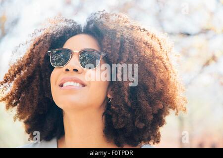 Porträt von Mitte Erwachsene Frau, Sonnenbrille, Lächeln, wegschauen hautnah Stockfoto