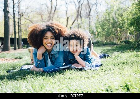 Mutter und Tochter hand liegend an Fronten, aufs Kinn, Blick in die Kamera Stockfoto