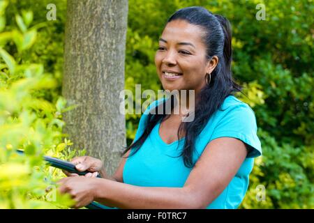 Reife Frau Schnitt Hecke im Garten Stockfoto