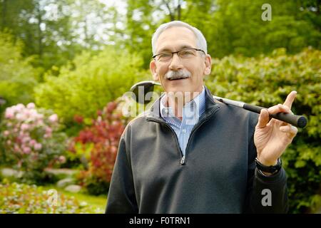 Porträt von senior woman holding Golf club Stockfoto