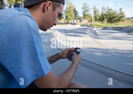 Junger Mann mit Smartphone im park Stockfoto