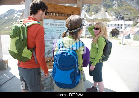 Touristen auf der Suche bei Informationstafel, Independence Mine State Historical Park, Hatcher Pass, Matanuska Valley, Palmer, Alaska Stockfoto