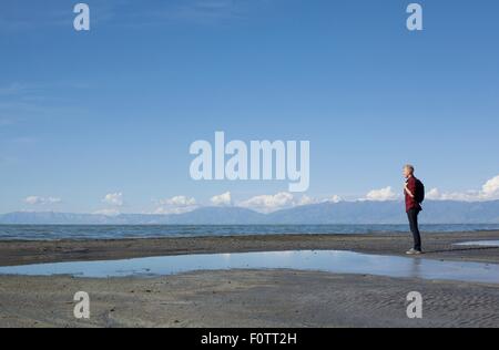 Seitenansicht der junge Mann, der am Rand des Wassers Ausschau, Great Salt Lake City, Utah, USA Stockfoto