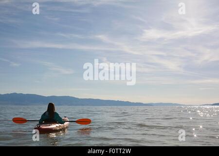 Rückansicht des jungen Frau Kajakfahrer sitzt im Kajak auf dem Wasser, Great Salt Lake City, Utah, USA Stockfoto