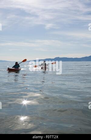 Kajaker sitzen in Kajaks auf dem Wasser vor der Bergkette Great Salt Lake City, Utah, USA Stockfoto