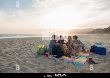 Gruppe von Freunden mit Picknick am Strand Stockfoto