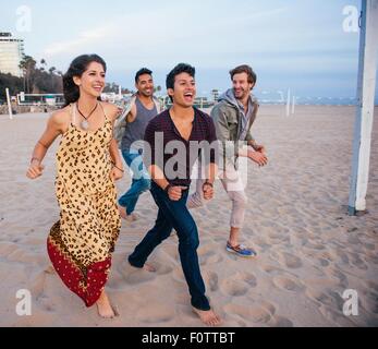 Gruppe von Freunden Strand entlang spazieren, lachen Stockfoto