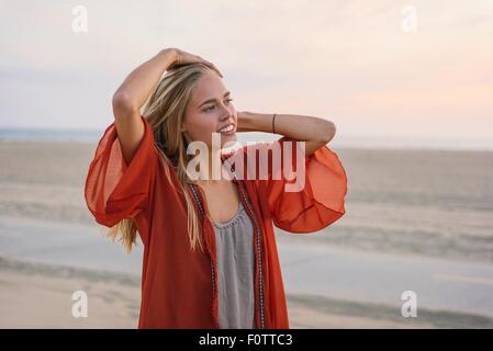 Junge Frau am Strand stehen, betrachten Stockfoto