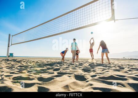 Gruppe von Freunden, die am Strand Volleyball spielen Stockfoto
