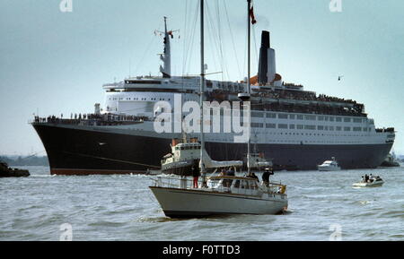 AJAXNETPHOTO. (SOU) 12. MAI 1982. SOUTHAMPTON, ENGLAND. -TRUPPENTRANSPORTER FÄHRT. DIE CUNARD LINER QE2 FÄHRT AM KAI IN SOUTHAMPTON, BELADEN MIT TRUPPEN FÜR DEN FALKLAND-INSELN.  FOTO: JONATHAN EASTLAND/AJAX.  REF: 909598/CD211031/13. Stockfoto