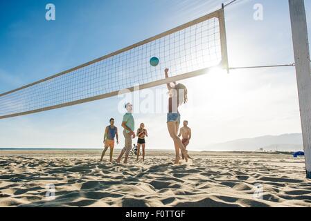 Gruppe von Freunden, die am Strand Volleyball spielen Stockfoto