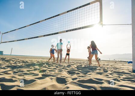 Gruppe von Freunden, die am Strand Volleyball spielen Stockfoto
