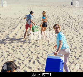 Gruppe von Freunden zu Fuß am Strand, bereit für Picknick Stockfoto