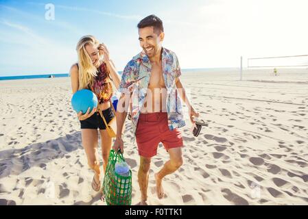 Junges Paar zu Fuß am Strand, bereit für Picknick Stockfoto