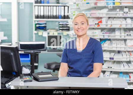 Zuversichtlich Assistant Sitzen im Kassenbereich in der Pharmazie Stockfoto