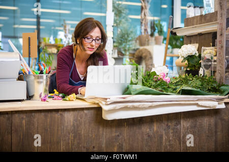 Mit Laptop am Schalter im Blumenladen Blumengeschäft Stockfoto