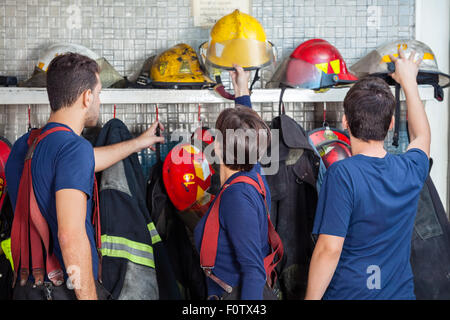 Feuerwehr Helme aus Regal entfernen Stockfoto