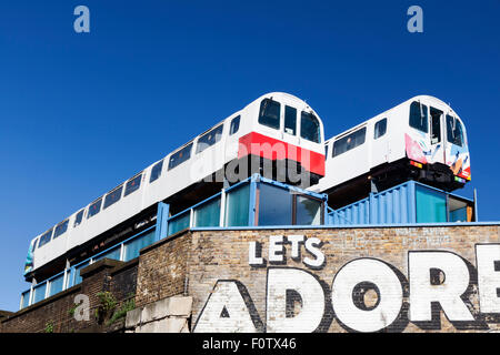 Dorf U-Bahn Rohr Zug Wagen es oben auf einem Gebäude am Shoreditch High Street in London, England. Stockfoto