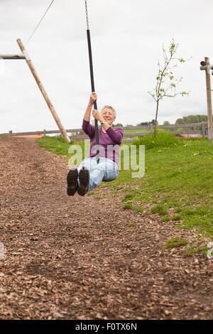 Ältere Frau spielt auf ZIP-Folie Stockfoto