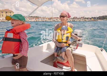 Reife Frau mit zwei jungen, die Lenkung Motorboot, Rovinj, Halbinsel Istrien, Kroatien Stockfoto