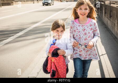 Zwei junge Mädchen gemeinsam Straße hinunter gehen, Lächeln Stockfoto