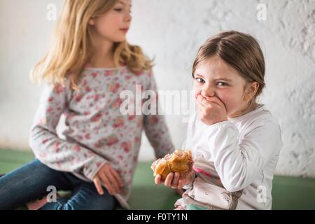 Zwei junge Mädchen essen herzhaft roll Stockfoto