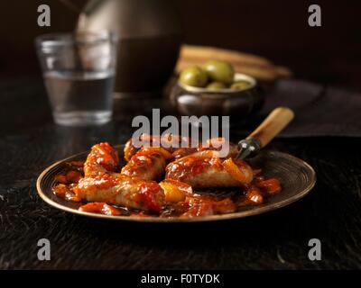 Teller mit cocktail-Würstchen mit pikanten Sauce und Schüssel mit grünen Oliven Stockfoto