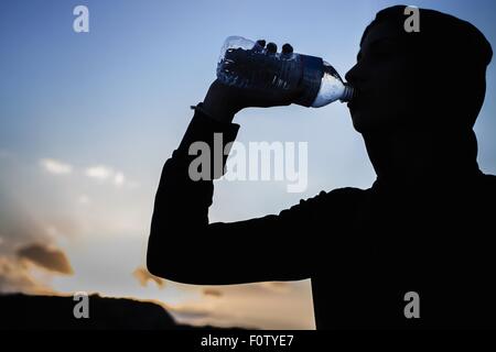 Junge Frau aus Flasche Wasser trinken Stockfoto