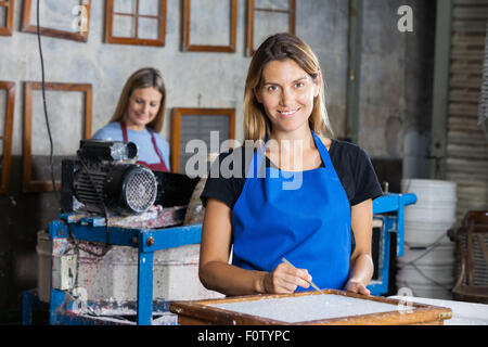 Zuversichtlich Arbeitnehmerin mit einer Pinzette, sauberes Papier auf Schimmel Stockfoto